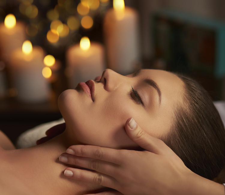Side view of young woman having facial massage in spa salon